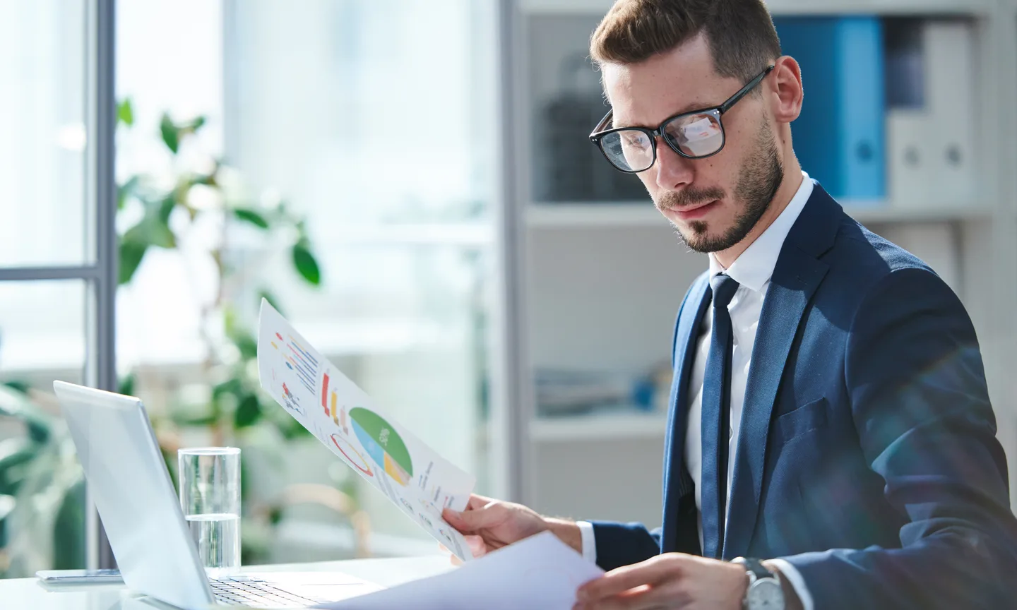 A professional reviewing printed financial charts