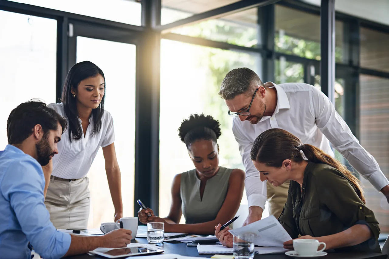 Colleagues reviewing reports together at a meeting table