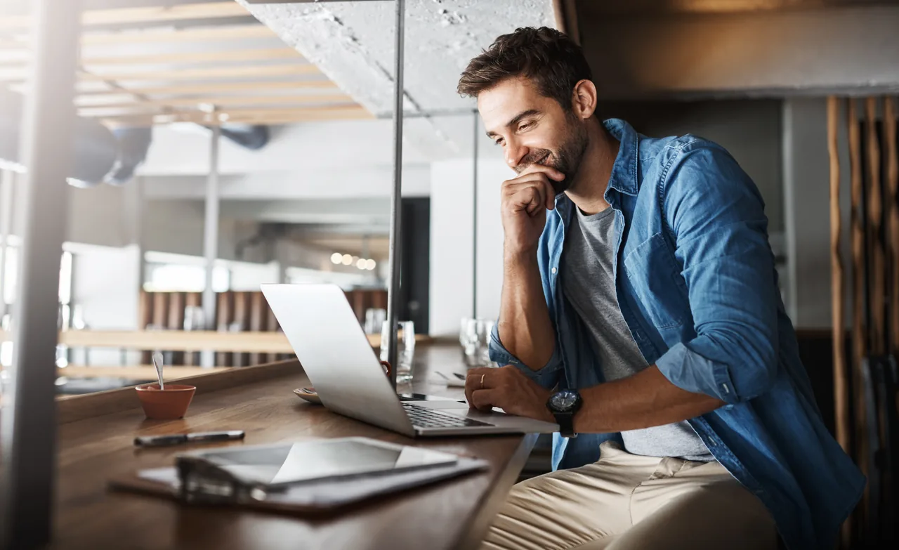 A professional considering information on a laptop
